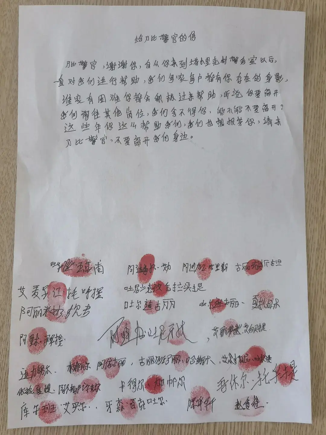 一名村民说着，将一张按满红手印的联名挽留信交到了阿卜杜乃比的手中。